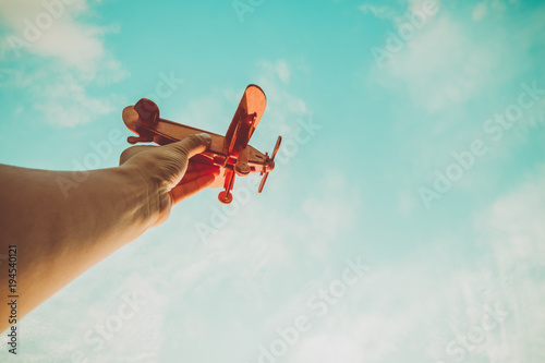 Toy airplane in hand - an inspiration of travel and dreams. Vintage color filter effect.