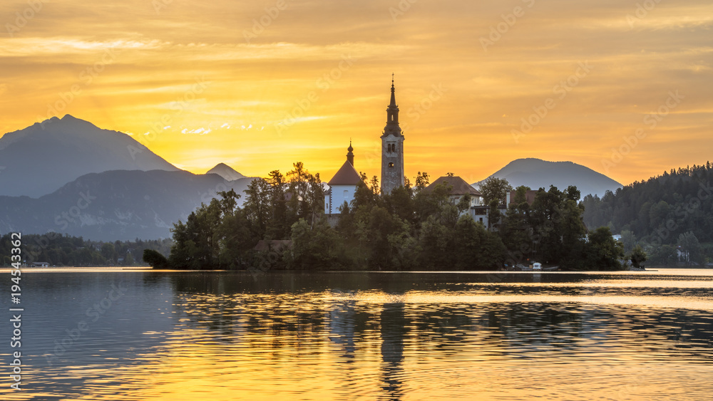 Famous Island in Lake bled with church under orange morning sky