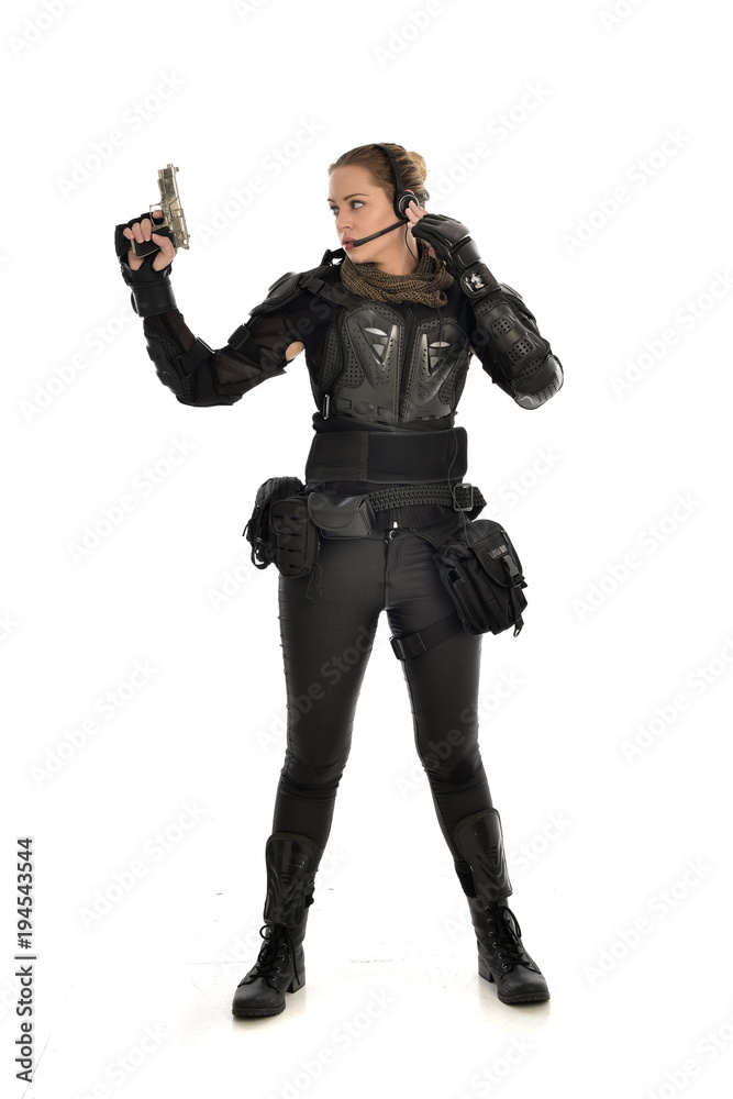 full length portrait of female soldier wearing black tactical armour, holding a gun, isolated on white studio background. full length portrait of female soldier wearing black tactical armour, holding a gun, isolated on white studio background.
