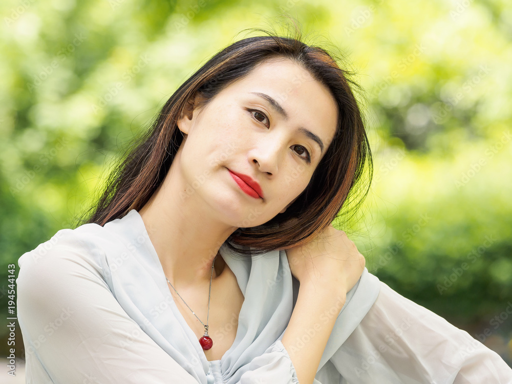 Beautiful young brunette Asian woman looking at camera with her head to one side. Outdoor fashion portrait of glamour young Chinese stylish lady. Emotions, people, beauty and lifestyle concept. Beautiful young brunette Asian woman looking at camera with her head to one side. Outdoor fashion portrait of glamour young Chinese stylish lady. Emotions, people, beauty and lifestyle concept.
