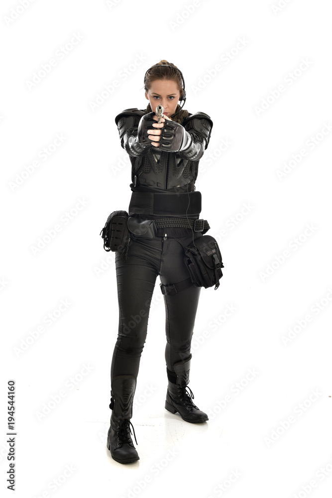 full length portrait of female soldier wearing black tactical armour, holding a gun, isolated on white studio background. full length portrait of female soldier wearing black tactical armour, holding a gun, isolated on white studio background.