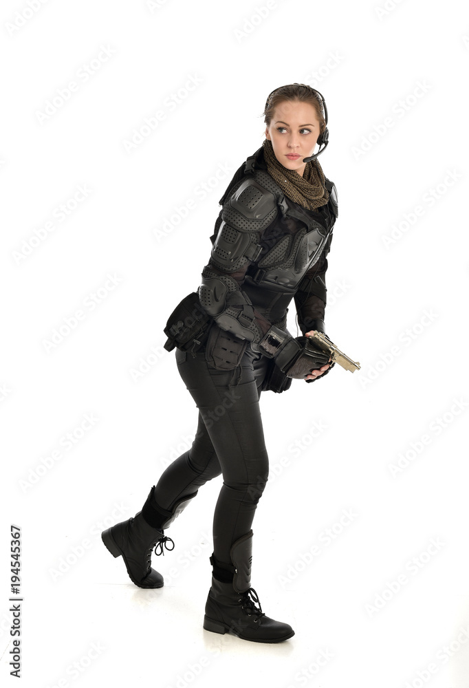 full length portrait of female soldier wearing black tactical armour, holding a gun, isolated on white studio background. full length portrait of female soldier wearing black tactical armour, holding a gun, isolated on white studio background.