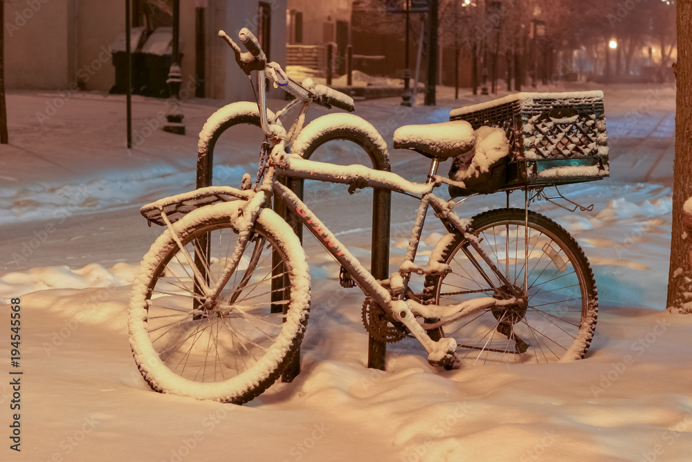 Snow covered bike with a milk crate basket in downtown Ann Arbor, Michigan