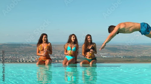 Man impressing women when jumping in a pool