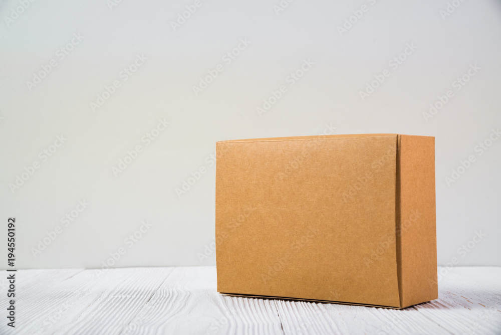 Empty Package brown cardboard box or tray on bright wooden table with copy space. Empty Package brown cardboard box or tray on bright wooden table with copy space.