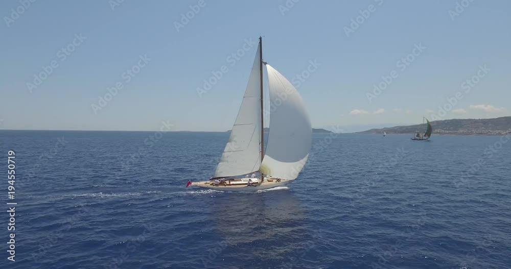 Aerial tracking shot of a traditional yacht sailing across Mediterranean seas Aerial tracking shot of a traditional yacht sailing across Mediterranean seas
