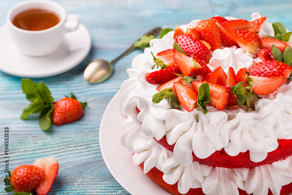 beautiful cake with strawberries and cream with tea ob blue wooden background beautiful cake with strawberries and cream with tea ob blue wooden background
