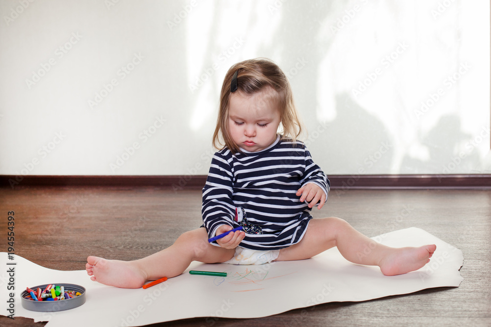 girl draws on the floor in the playroom