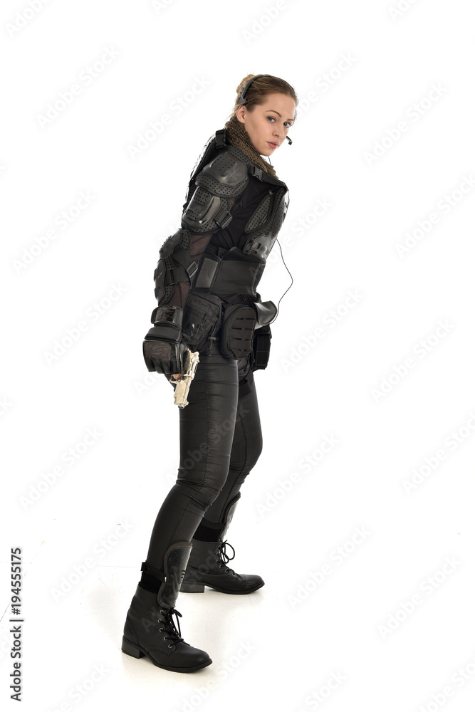 full length portrait of female soldier wearing black tactical armour, holding a gun, isolated on white studio background. full length portrait of female soldier wearing black tactical armour, holding a gun, isolated on white studio background.
