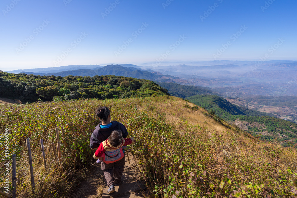 Doi Inthanon National Park, The hill tribe carrying a child walk on the top highest mountain of Thailand