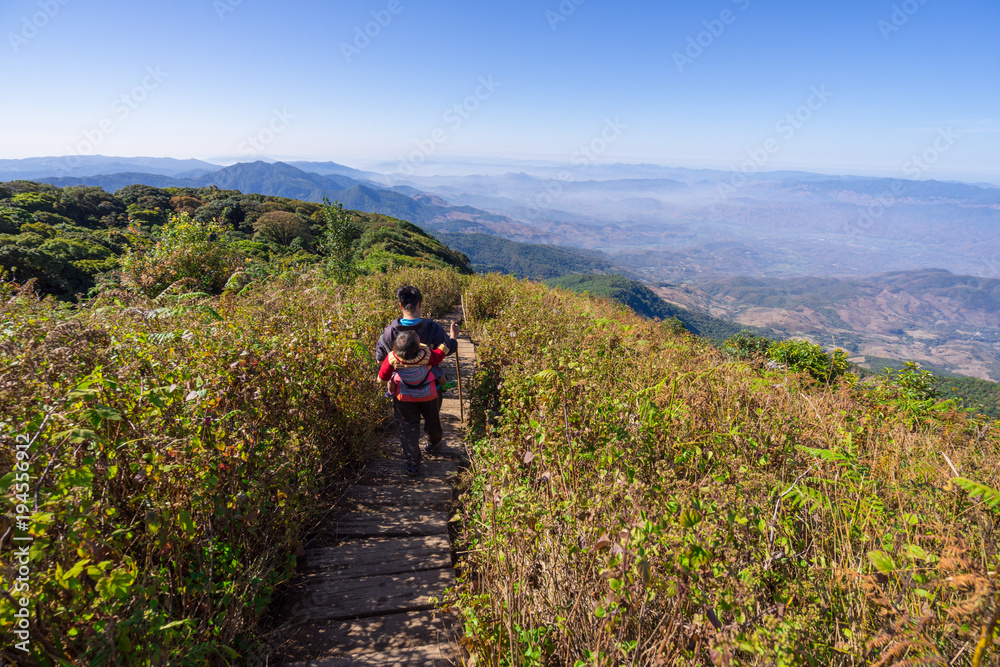 Doi Inthanon National Park, The hill tribe carrying a child walk on the top highest mountain of Thailand