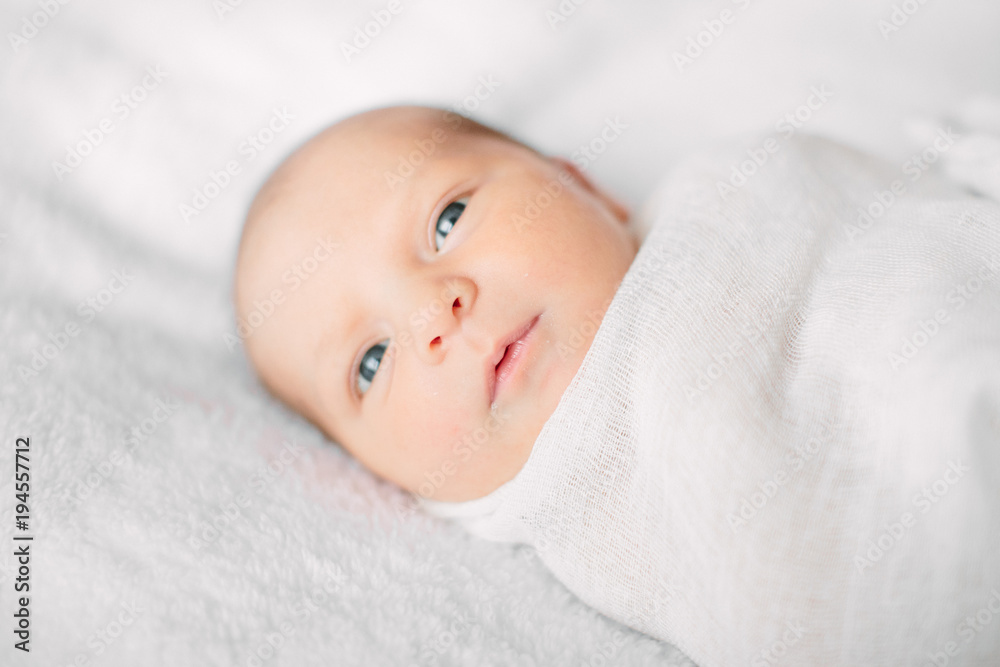 Cute newborn girl lying on furry cloth wearing white headband Cute newborn girl lying on furry cloth wearing white headband