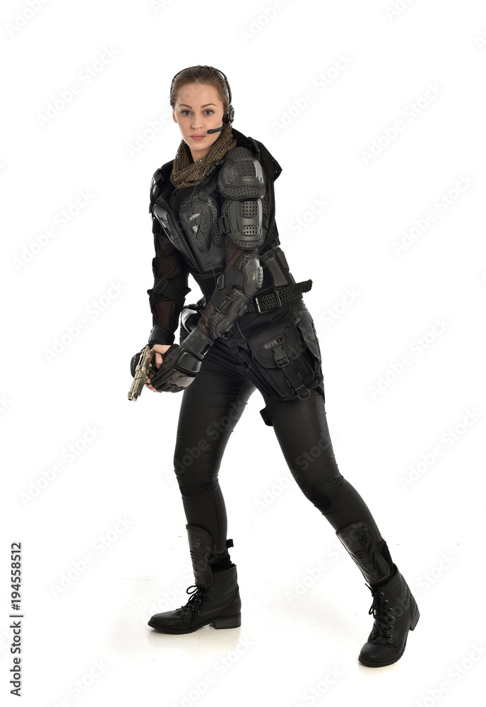 full length portrait of female soldier wearing black tactical armour, holding a gun, isolated on white studio background. full length portrait of female soldier wearing black tactical armour, holding a gun, isolated on white studio background.