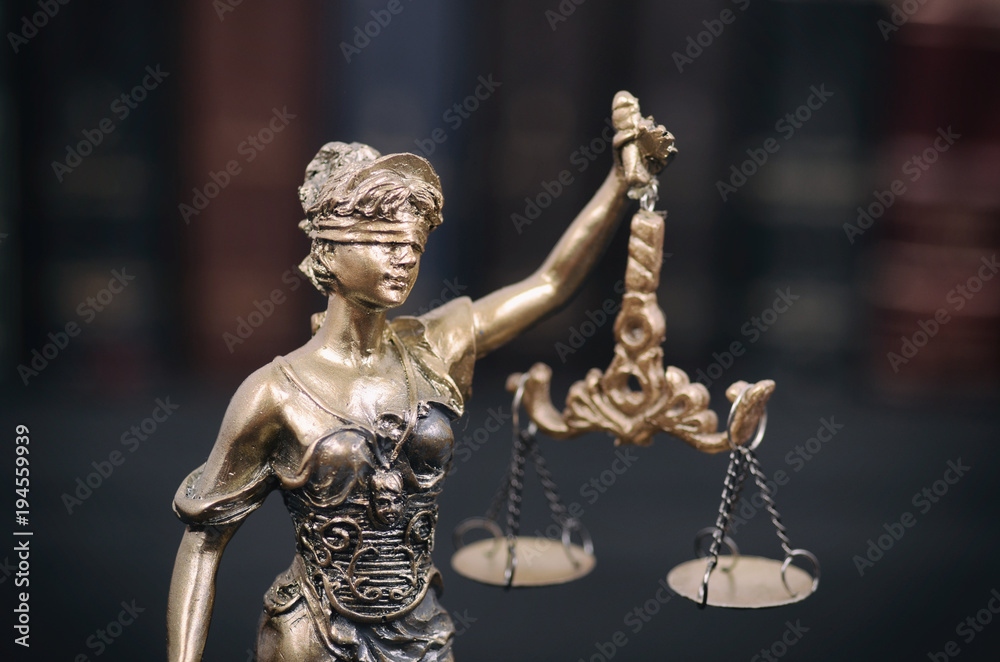Scales of Justice, Justitia, Lady Justice and Law books in the background.