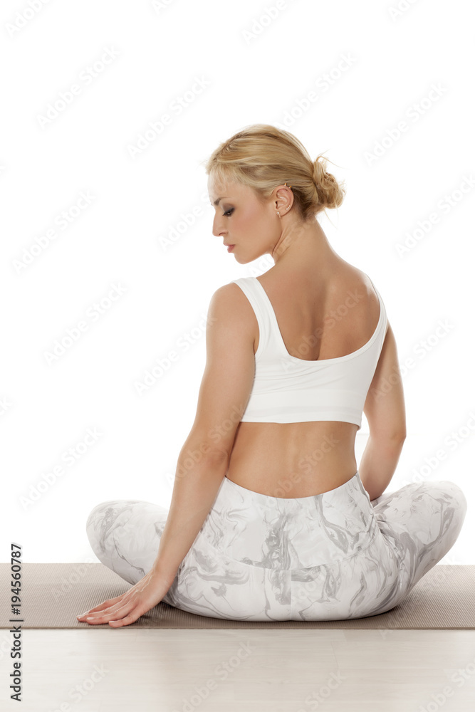 Yoga, sport, training and lifestyle concept - Young blonde woman relaxes while exercising yoga Portrait of young beautiful woman in white sportswear in relax pose. Yoga, sport, training and lifestyle concept - Young blonde woman relaxes while exercising yoga Portrait of young beautiful woman in white sportswear in relax pose.