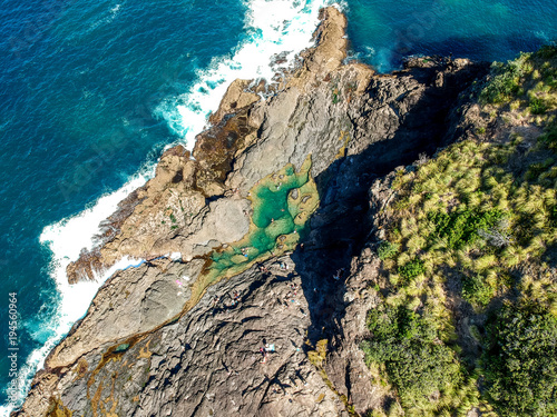 Stunning wide angle aerial drone view of the Mermaid Rock Pools and ocean waves at Matapouri Bay near Whangarei on the North Island of New Zealand. The rock pools are a popular tourist destination. photo