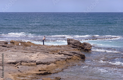 lone surf fisherman on the rocks at Caesarea on the Mediterranean © Sarit Richerson