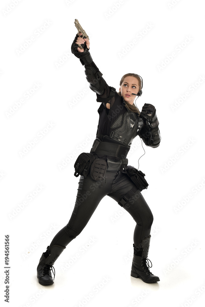 full length portrait of female soldier wearing black tactical armour, holding a gun, isolated on white studio background. full length portrait of female soldier wearing black tactical armour, holding a gun, isolated on white studio background.