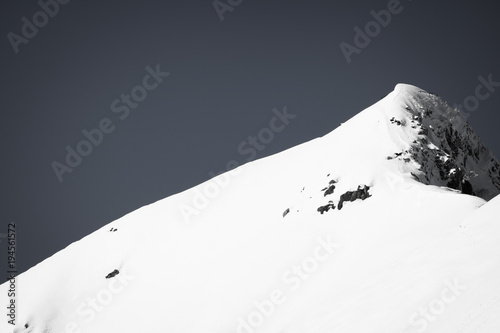 close up view on beautiful snowcapped rocky mountain range in pyrenees in black and white, france