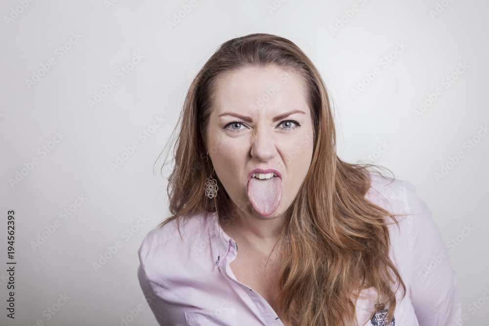 frau mit heraus gestreckter zunge StockFoto Adobe Stock