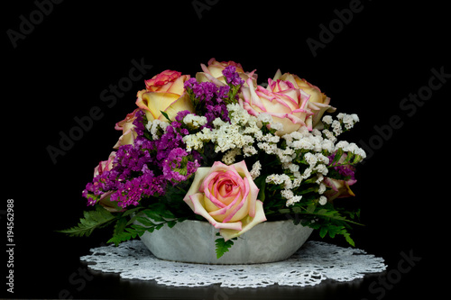yellow-pink roses in vase on black background