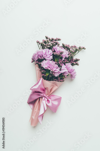 top view of beautiful tender elegant flower bouquet with pink ribbon isolated on grey