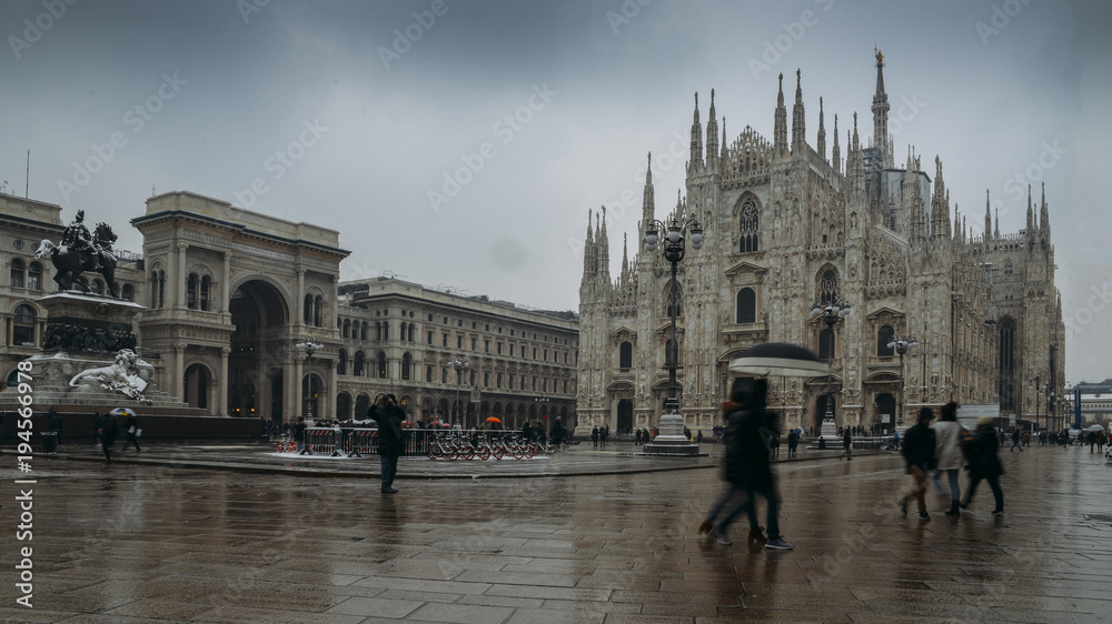 Tourists and locals at Piazza del Duomo in Milan, Lombardy, Italy with the Galleria Vittorio Emanuele II, and Duomo church cathedral