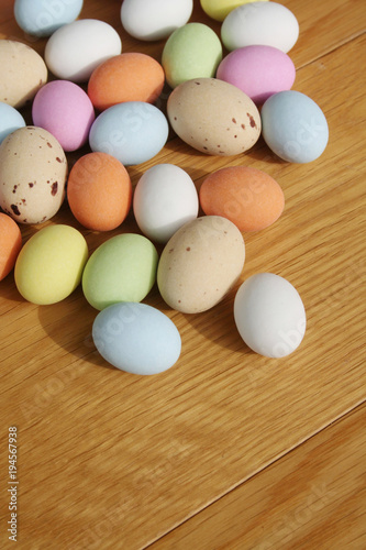 Multicolored chocolate Easter eggs on wooden table. Easter background