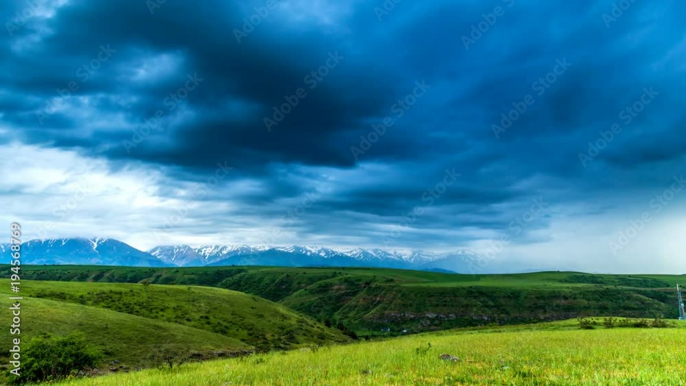 4K TimeLaps. Dark thunderclouds move quickly over the mountains and fields in the spring 4K TimeLaps. Dark thunderclouds move quickly over the mountains and fields in the spring