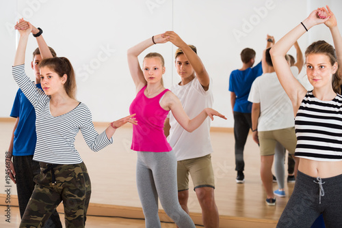 Group of friendly teen dancing tango in dance studio