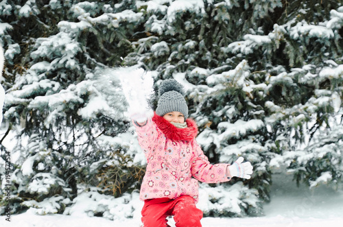 Fototapeta Naklejka Na Ścianę i Meble -  Cute smiling toddler girl portrait. outdoors on a sunny winter snowy day, walking