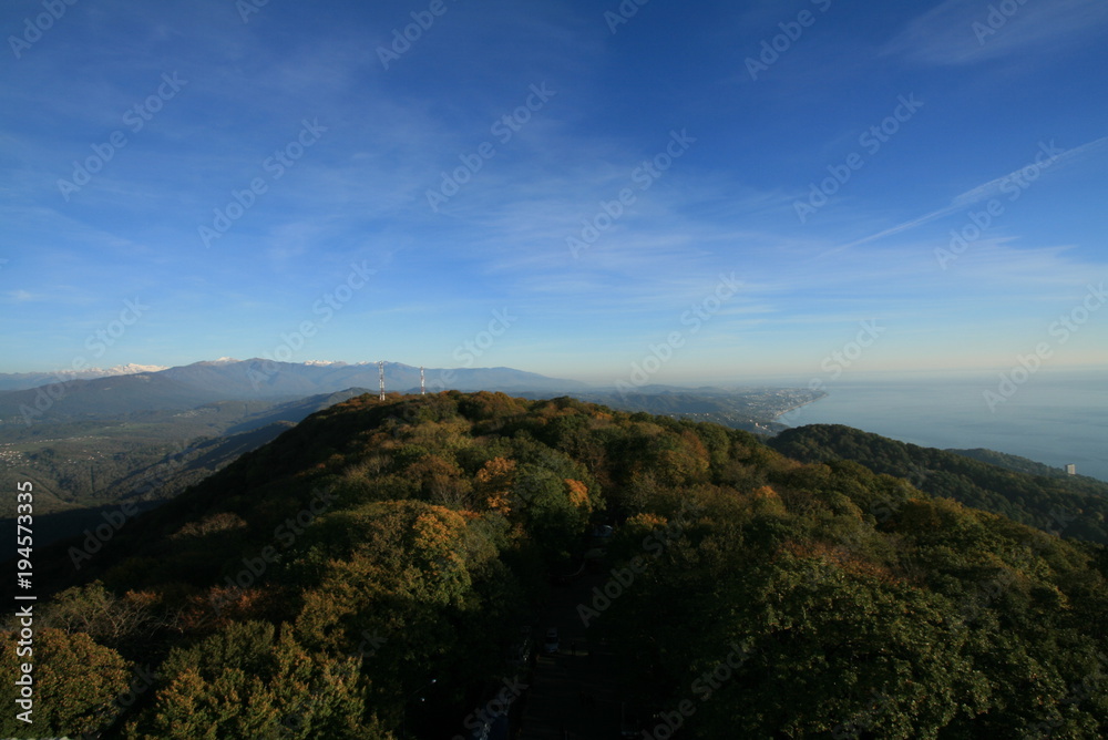 panorama of mountains covered with forest against the sky with clouds