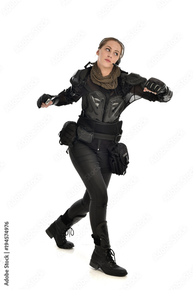 full length portrait of female soldier wearing black tactical armour, holding a remote knife, isolated on white studio background. full length portrait of female soldier wearing black tactical armour, holding a remote knife, isolated on white studio background.