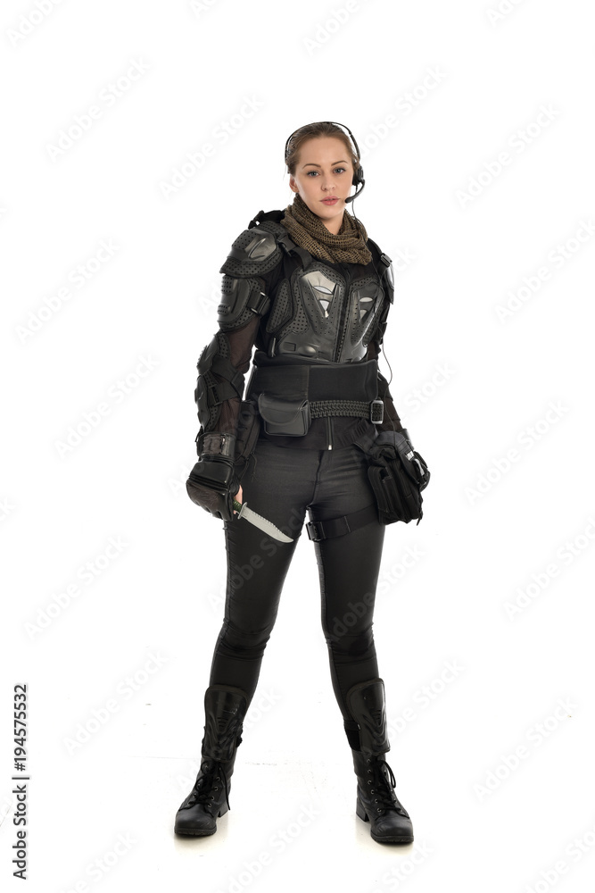full length portrait of female soldier wearing black tactical armour, holding a remote knife, isolated on white studio background. full length portrait of female soldier wearing black tactical armour, holding a remote knife, isolated on white studio background.