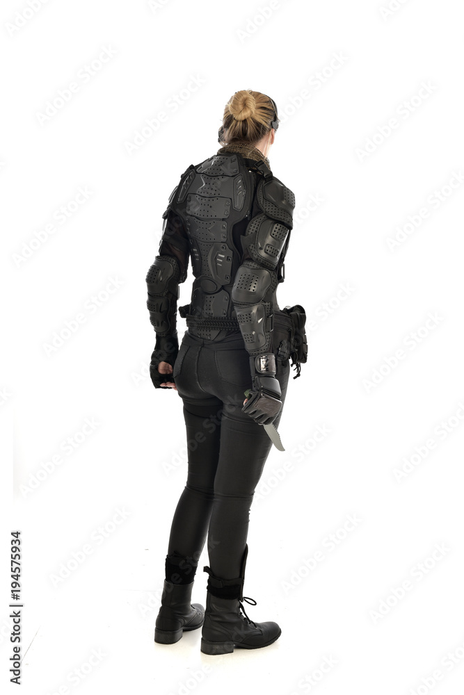 full length portrait of female soldier wearing black tactical armour, holding a remote knife, isolated on white studio background. full length portrait of female soldier wearing black tactical armour, holding a remote knife, isolated on white studio background.