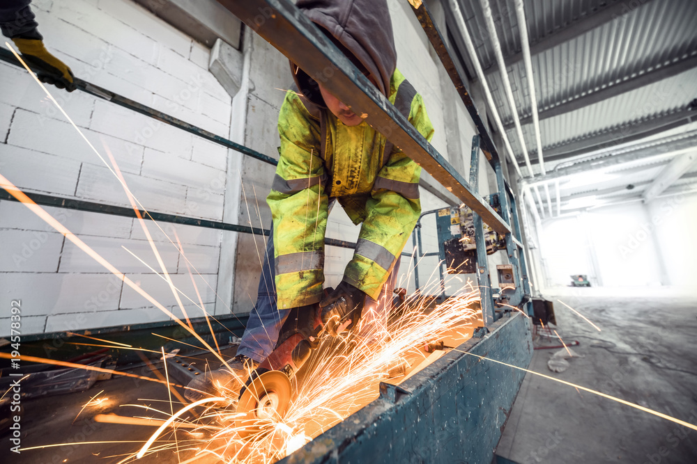 Worker cutting steel with grinder 