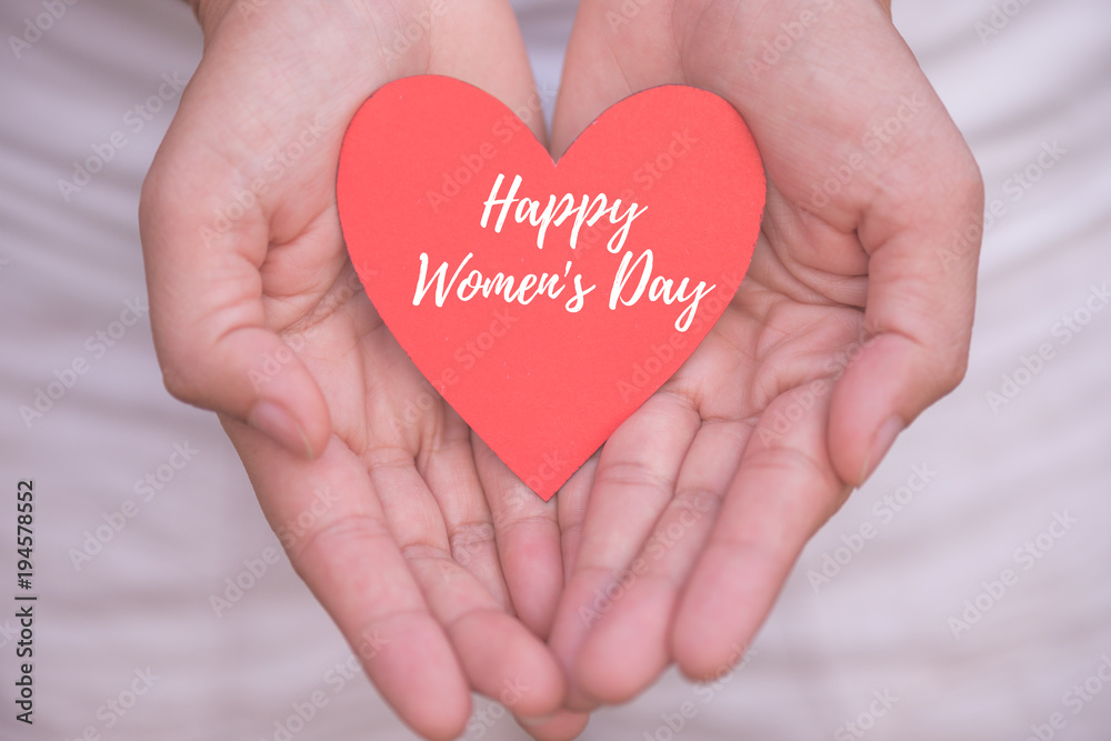 Young woman hand holding red heart paper with Happy Women's Day message. Happy Womens Day concept. Young woman hand holding red heart paper with Happy Women's Day message. Happy Womens Day concept.