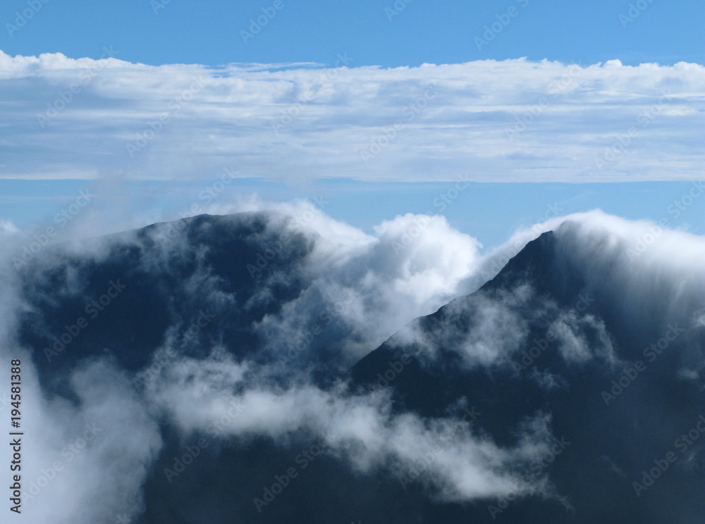 Saint Paul / La Reunion: View from the Maido peak over the surrounding steep mountain slopes in the Cirque de Mafate in the early morning when orographic clouds begin to cover the landscape