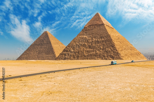 The Egyptian pyramids of Giza on the background of Cairo. Miracle of light. Architectural monument. The tombs of the pharaohs. Vacation holidays background wallpaper
