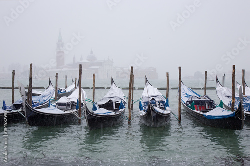 Snow on Venetian Gondolas  Grand Channel  St. Mark square  snowing in Venice  Italy  march 2018
