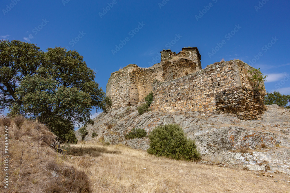 Ruined Alba castle over the rocks against blue sky