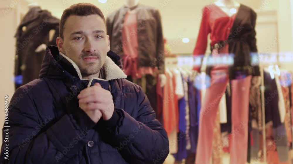 Young frozen man looks at the shop window Young frozen man looks at the shop window