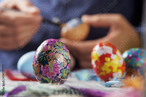 young man decorating easter eggs