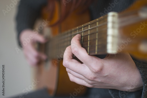 Woman hands playing acoustic guitar. Selective focus
