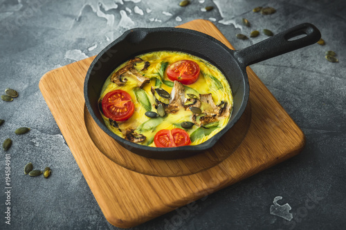 Healthy vegetarian omelet in frying pan and pumpkin seeds.