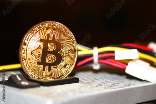 Golden Bitcoin virtual currency, colored electrical wires photo
