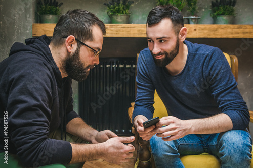 Two friends watching media content in a smart phone