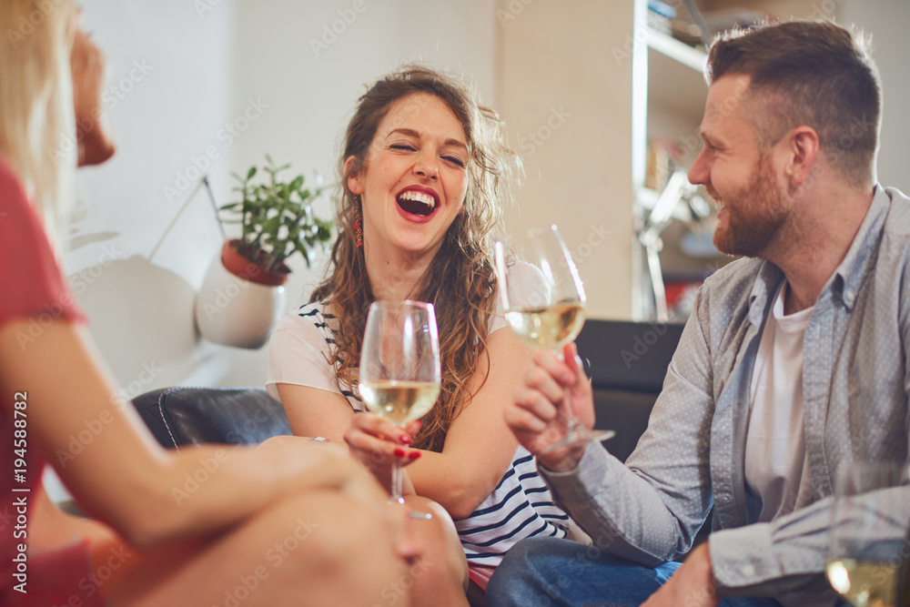 Friends cheering with wine at house party. Friends cheering with wine at house party.