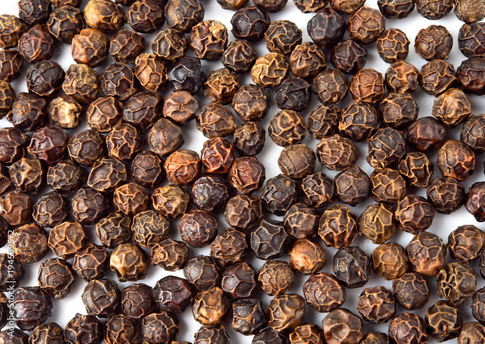 Obraz premium Black Pepper on white background. Peppercorns background, texture. Top view.