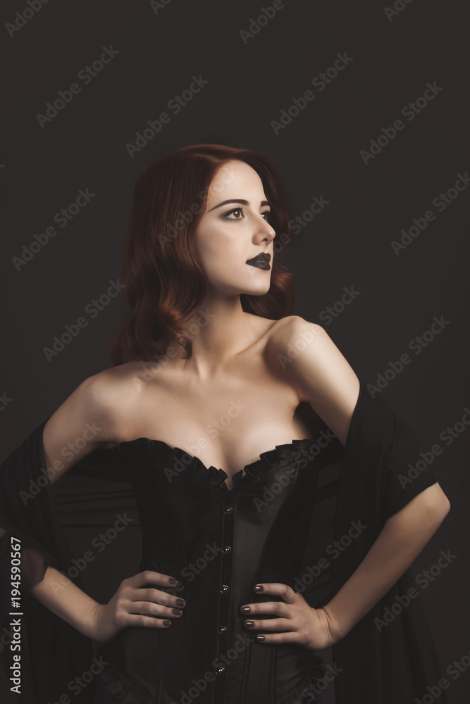 Young redhead woman in  black corset